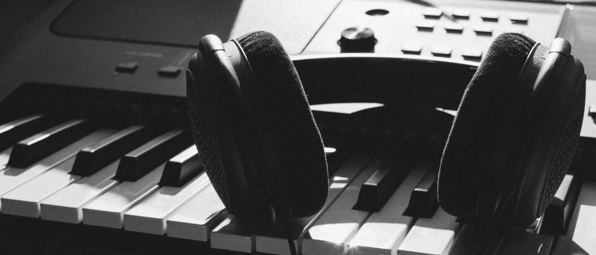black wireless headphones on gray electronic keyboard