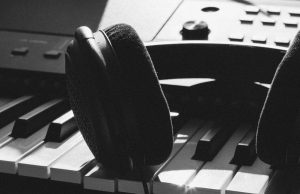 black wireless headphones on gray electronic keyboard