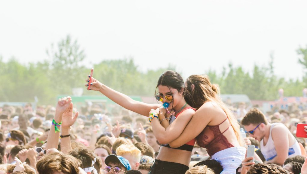 two women embracing surrounded by crowd