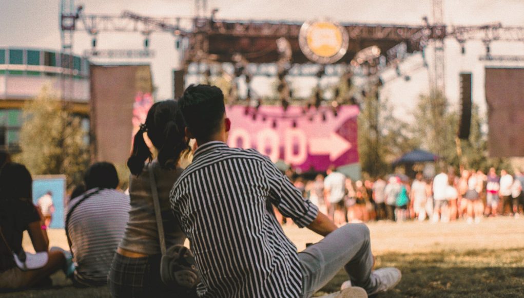 photo of couple sitting on grass field