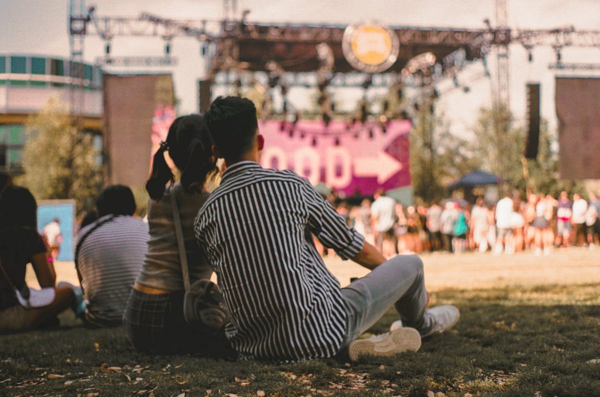 photo of couple sitting on grass field