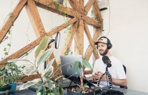 a man in white shirt doing audio podcast