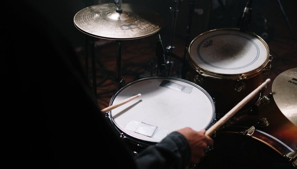 person in black long sleeve shirt playing drum