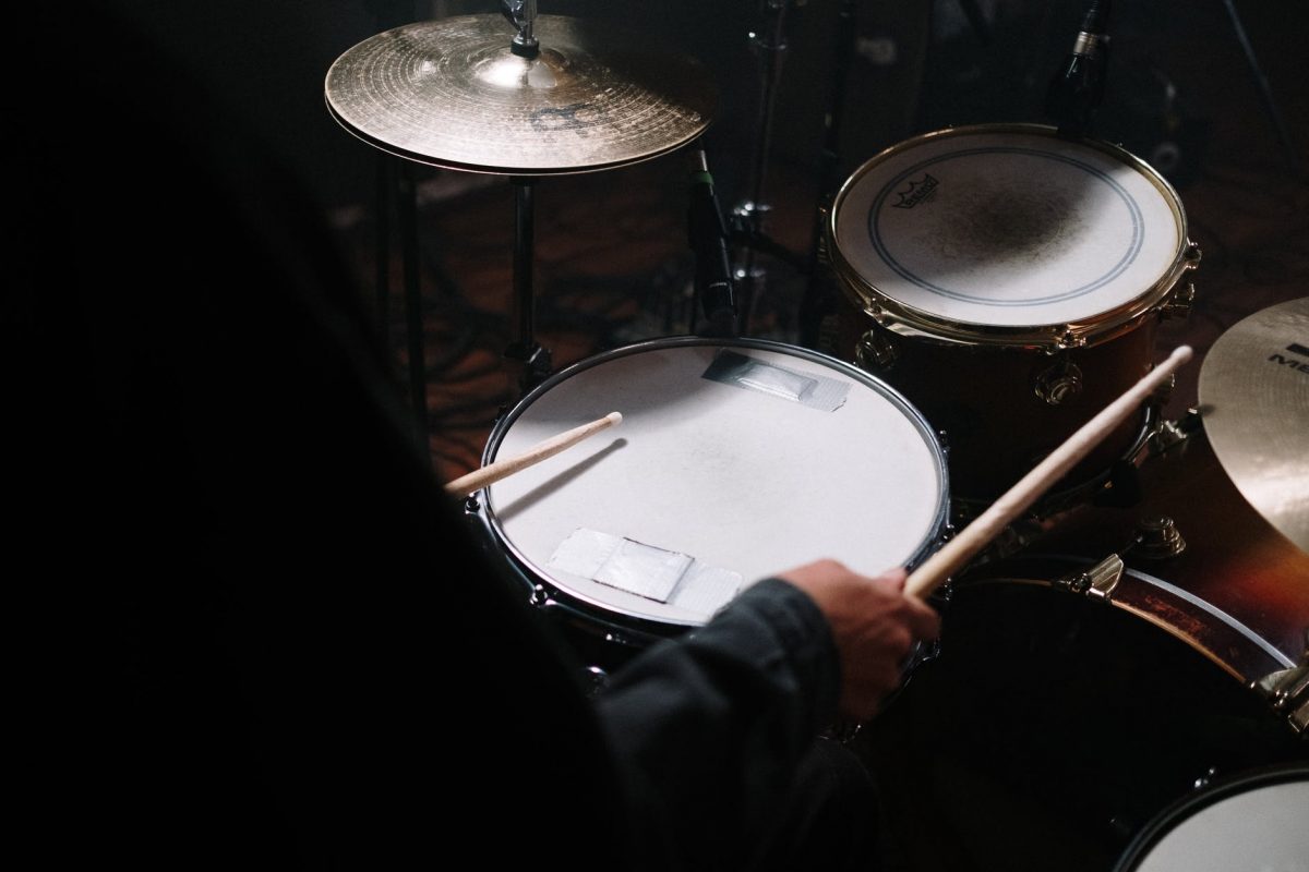 person in black long sleeve shirt playing drum