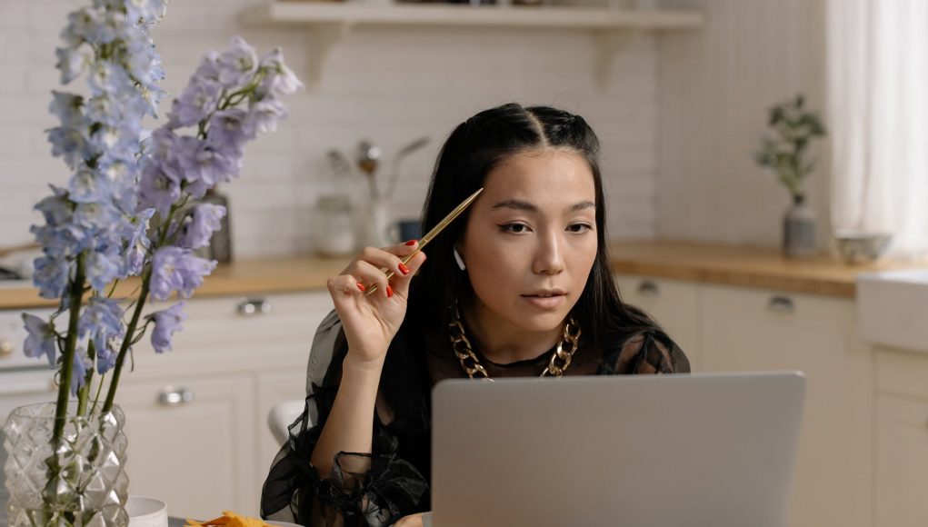 beautiful woman with red nails looking at a laptop