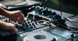 Artist Interview: YouNotUs person playing dj mixer