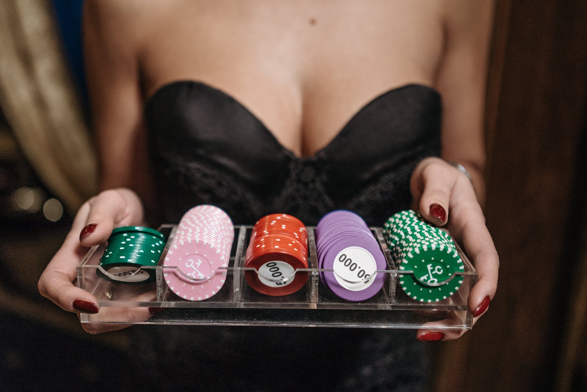 a person holding a tray of casino chips