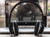 photo of black wireless headphones in front of the laptop