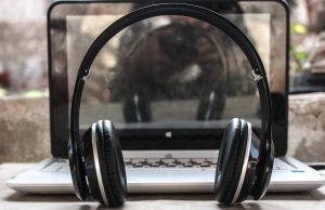 Ombra INTL022: Dilation & Truth photo of black wireless headphones in front of the laptop