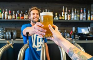 Tractor – proudly brewed in Ukraine – Das Solidaritätsbier für Land und Leute im Krieg man handing a person a glass of beer