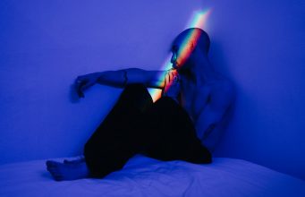 Queerness in Photography @ C/O Berlin man in black pants sitting on bed