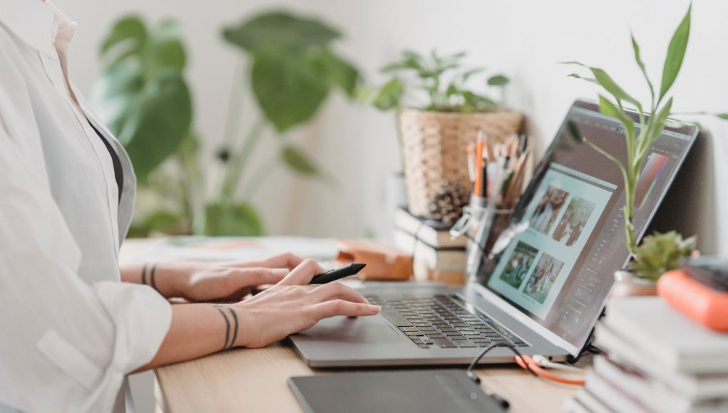 woman working retouching photo on laptop at convenient workplace